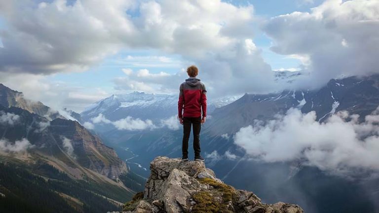 man standing on a mountain looking out