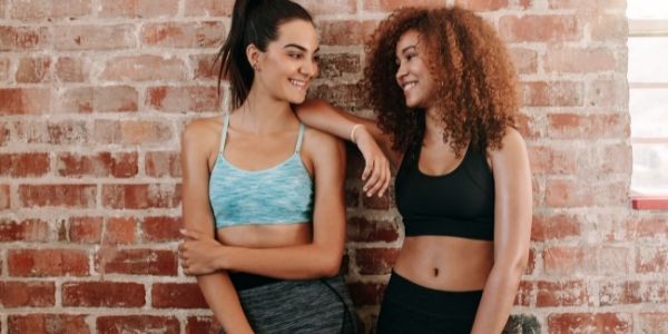 two ladies in workout clothes smiling