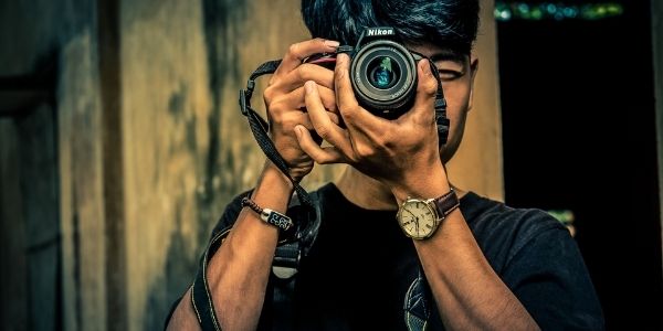 guy holding a nikon camera