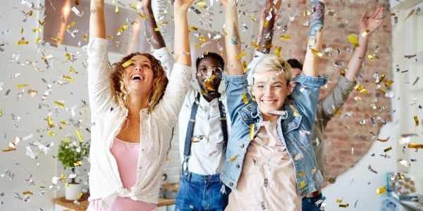 four people with arms in the air celebrating
