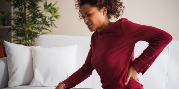 lady sitting on the couch with lower back pain