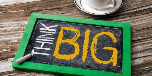 small chalk board on a table with the words think big