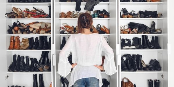 lady standing in front of a messy shoe closet