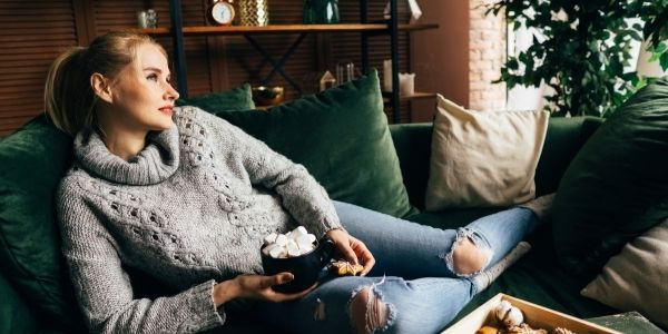 lady sitting on the couch with hot chocolate and a star cookie
