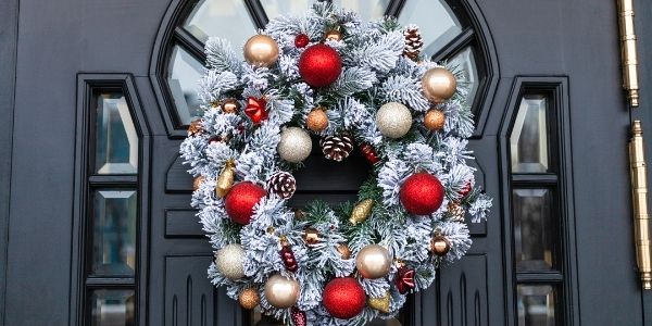 black front door with a Christmas wreath on it