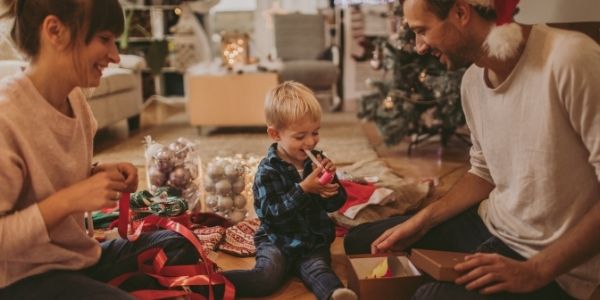 mom and dad with son wrapping gifts