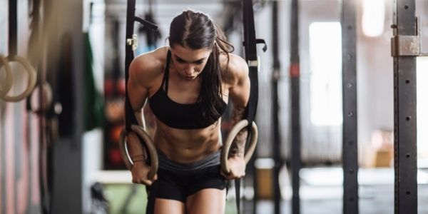 lady doing dips on a rings