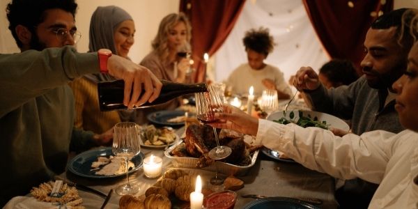 7 people sitting around a table have turkey dinner