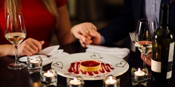 two people sitting at a table sharing a dessert