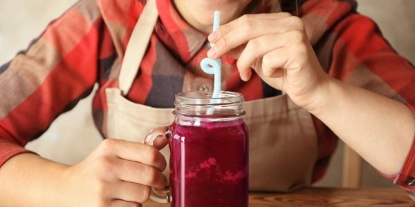 person drinking a beet smoothie