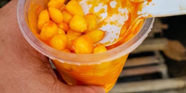 man holding cup of corn