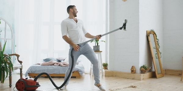 man using vacuum as a guitar