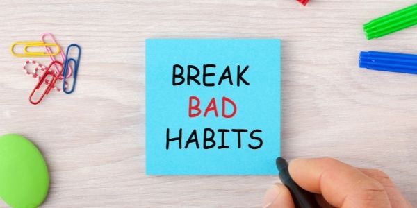 sticky note on a desk with the words written break bad habits
