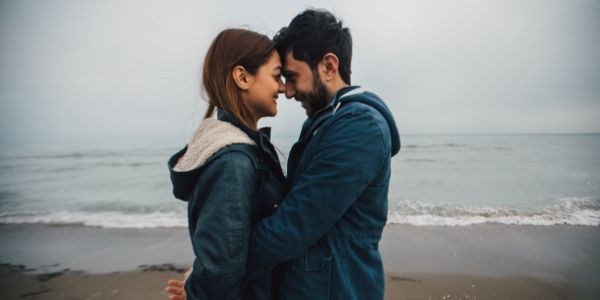 couple hugging face to face on the beach