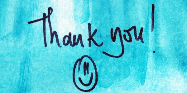 blue painted wall with the words Thank you on it and a smile face