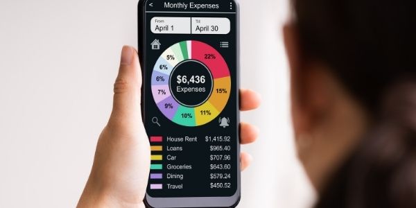 lady looking at a phone with a habit tracking app on the screen