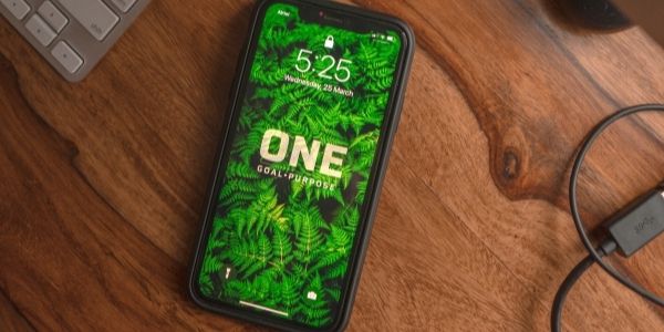 iphone with wallpaper that says one goal on purpose