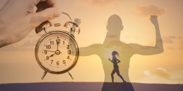 lady running with a her shadow flexing in the background and a clock