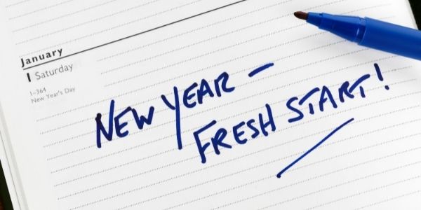 Piece of paper with the words new year - fresh start in blue ink