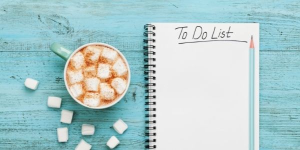 hot chocolate with marshmallow beside a note book with to do list written on it