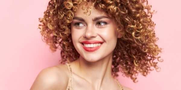 lady smiling against pink background