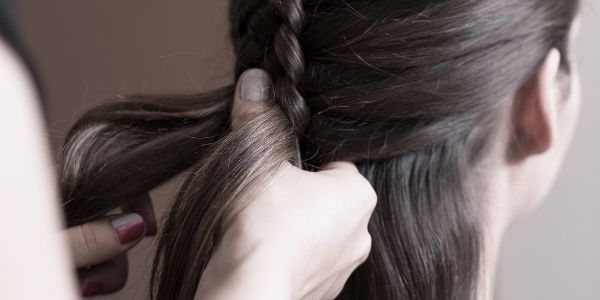 person braiding another persons hair