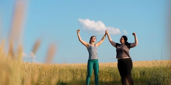two ladies in a field celebrating