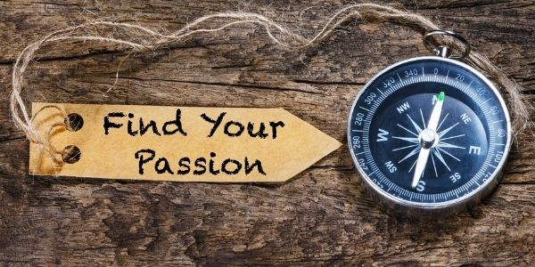 note saying find your passion placed beside a compass