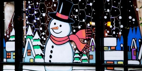 winter painting snowman with scarf and tophat trees and house in background