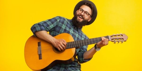 man playing guitar - bright yellow background